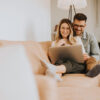 Mann und Frau mit Laptop auf Sofa