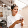 Frau die auf ihrem Smartphone Online Marketing für Immobilienmakler prüft