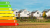 Skala der Energieeffizienzklasse mit Immobilien im Hintergrund