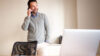 Mann der telefoniert mit Laptop und Tablet vor sich