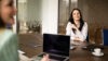 Zwei Frauen im Büro die am Schreibtisch sitzen und sich über Informationspflicht für Makler unterhalten