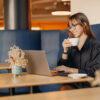 Junge Frau sitzt im Café an ihrem Laptop