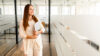 Frau mit Tablet in der Hand in hellem Flur