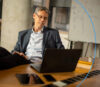 Mann der am Laptop die passende Immobiliensoftware auswählt