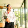 Frau, die mit Tablet in der Hand in die Ferne schaut