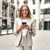 Frau mit Handy in der Hand auf der Straße